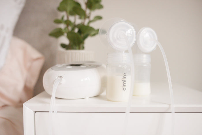 breast pump with collection bottles after pumping milk on table
