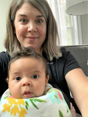 mom and baby looking happily at the camera