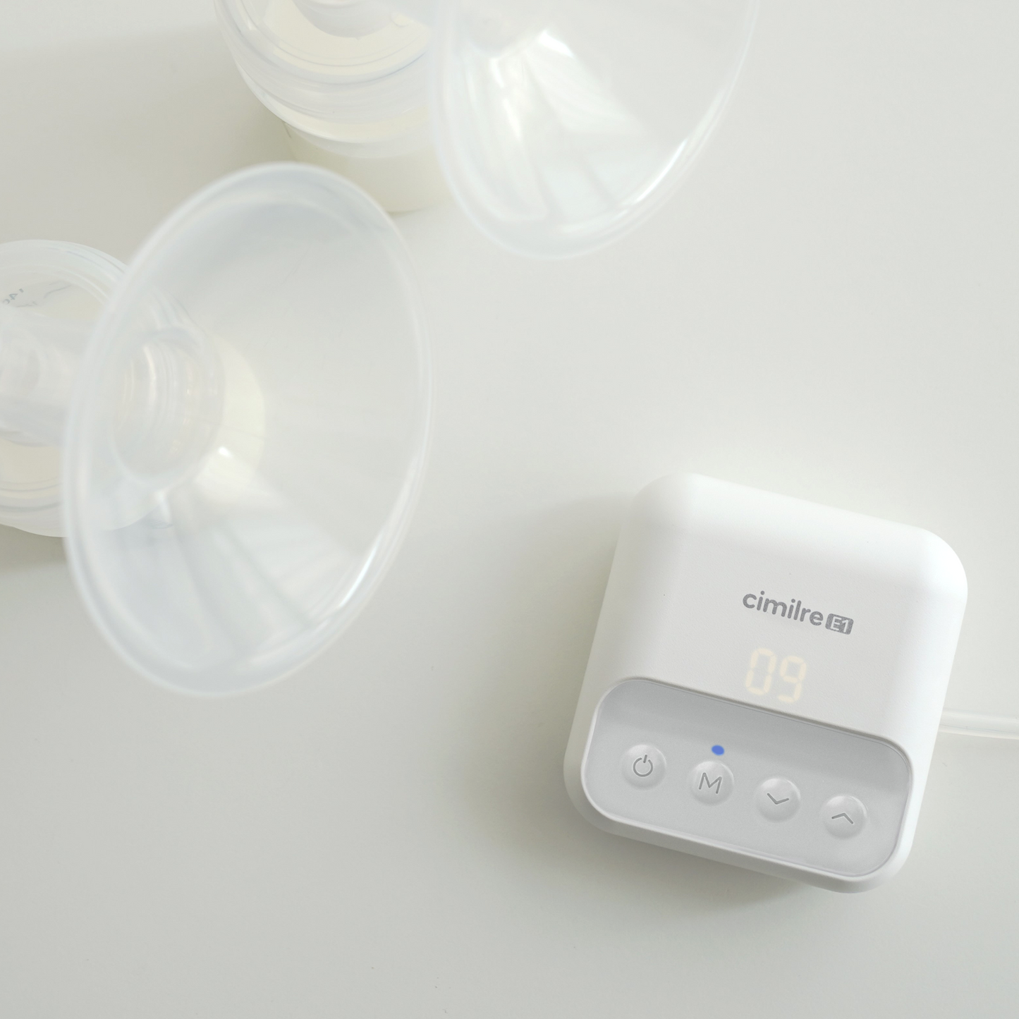 e1 breast pump next to collection kit with milk in the bottles
