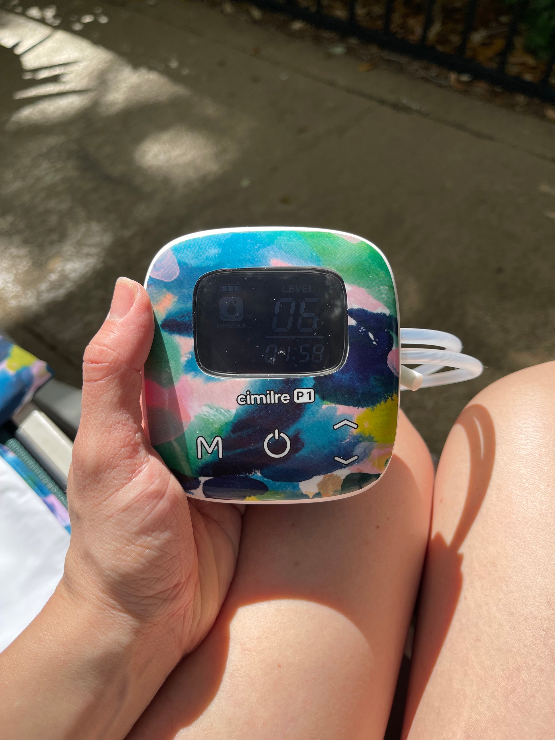 somone holding p1 breast pump with aquarelle skin decal outside