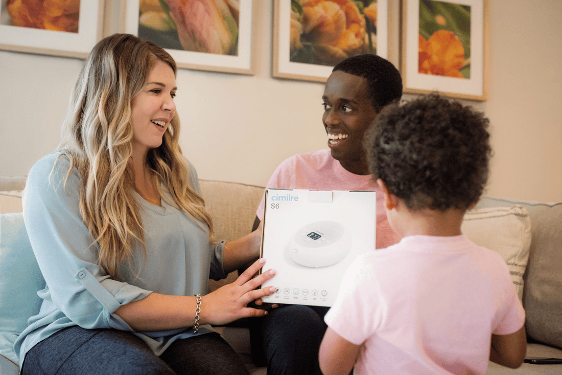Family together while holding a cimilre s6 breast pump box