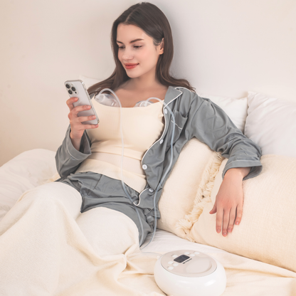 woman in bed pumping with the Cimilre hands free collection cups and S6+ looking at her phone