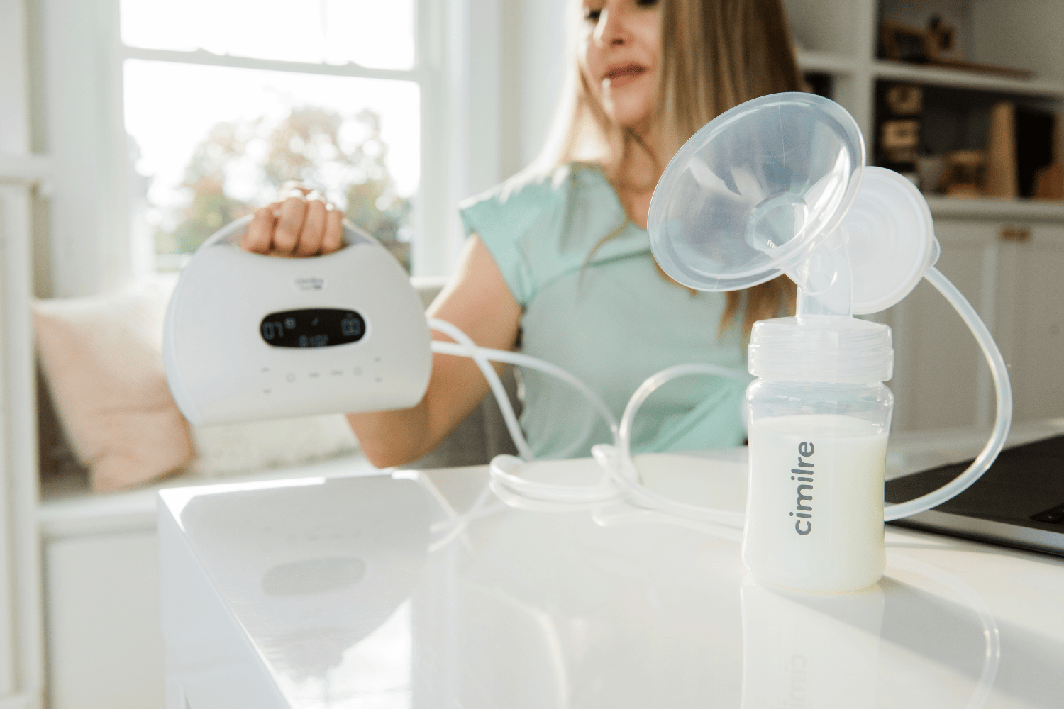 mom holding S7 dual pro in the background, with a milk collection kit in the front