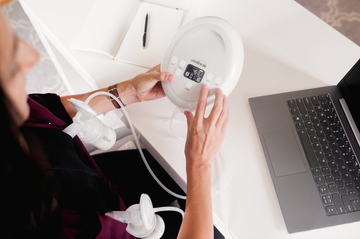 mom sitting at a desk working while pumping with cimilre s6+ breast pump