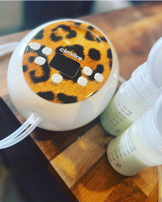 s6+ breast pump with leopard skin decal next to collection kit with milk in them