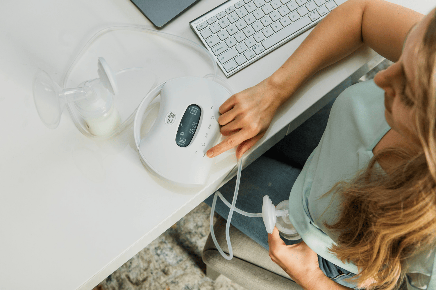 mom pumping at work with dual motor breast pump, adjust settings for one side